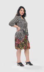 Load image into Gallery viewer, Right side full body view of a woman wearing the alembika sunset wonderful dress. This dress has a button down front, black and white striped print and a floral printed bottom. The dress has 3/4 length sleeves and sits at the knees.
