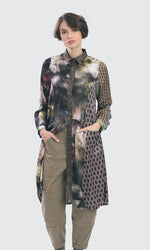 Load image into Gallery viewer, front full body view of a woman wearing the alembika supernova wonderful dress. This dress has a button up front, long sleeves, a shirt collar, princess seams, and a tie-dye print mixed with retro print.
