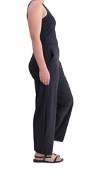 Load image into Gallery viewer, Right side, full body view of a woman wearing the Alembika Riding Pant. This pant is black with wide legs that slightly taper in at the bottom. They also have side pockets.

