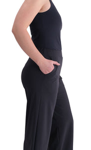 Right side, close up view of a woman wearing the Alembika Riding Pant with her hand in the pocket. This pant is black with wide legs.