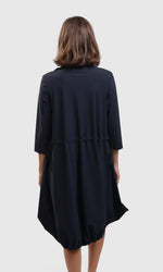 Load image into Gallery viewer, Back top half view of a woman wearing the alembika tekbika navy Dress. This dress sits at the knees and has a bubble skirt and 3/4 length sleeves. The back has a cinch at the waist.
