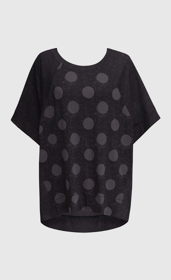 Front view of the alembika circles top. This top is a washed black with solid black short raglan sleeves and a grey dotted print on the torso.