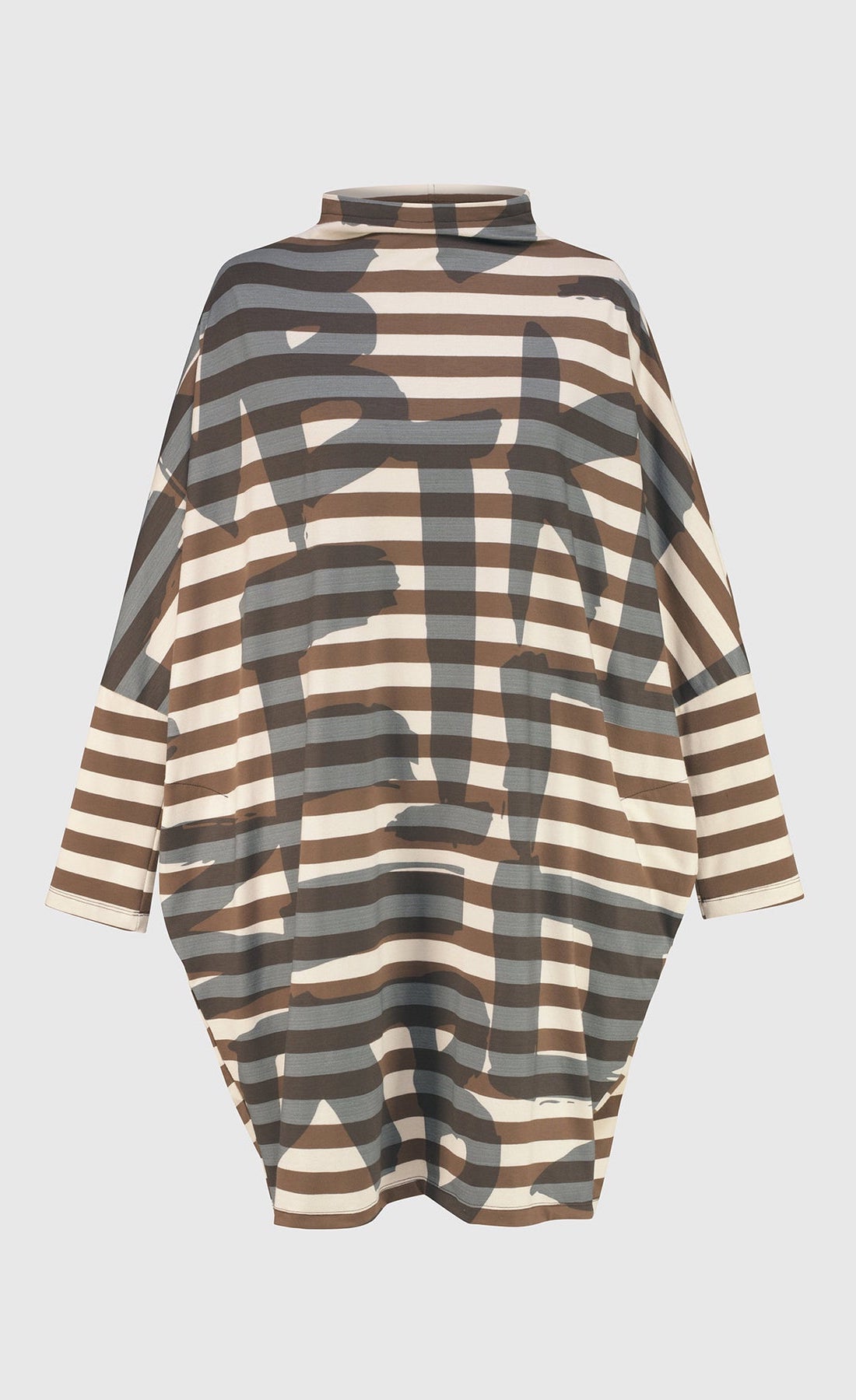 Front of the Alembika Urban Clustur Cocoon Dress. This dress is cream and brown striped with a gray graffiti print all over it. The dress has a cocoon shape that tapers in at the knees. It has drop shoulder, long dolman sleeves and a mock neck.