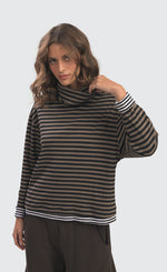 Load image into Gallery viewer, front top half view of a woman wearing the Alembika urban gateau cowlneck top in the brown and black striping. The top has a cowlneck, a relaxed fit, and contrasting black and white hems and cuffs.
