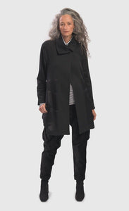 Front full body view of a woman wearing the alembika urban sleek satin trim jacket in black. This jacket has a single button closure and satin panels on the side.