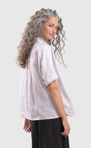 Right side top half view of a woman wearing the alembika striped white cactus shirt. This white shirt has black pinstripes, a button down front, short sleeves, and a collar.