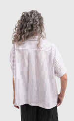 Load image into Gallery viewer, Back top half view of a woman wearing the alembika striped white cactus shirt. This white shirt has black pinstripes, short sleeves, a collar, and a yoked back.
