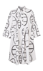 Load image into Gallery viewer, Front view of the alembika cotton print shirt. This shirt goes down to the knees and has elbow length sleeves. It features a button up front with a collar. It is white with a black circle/capsule like print all over it.
