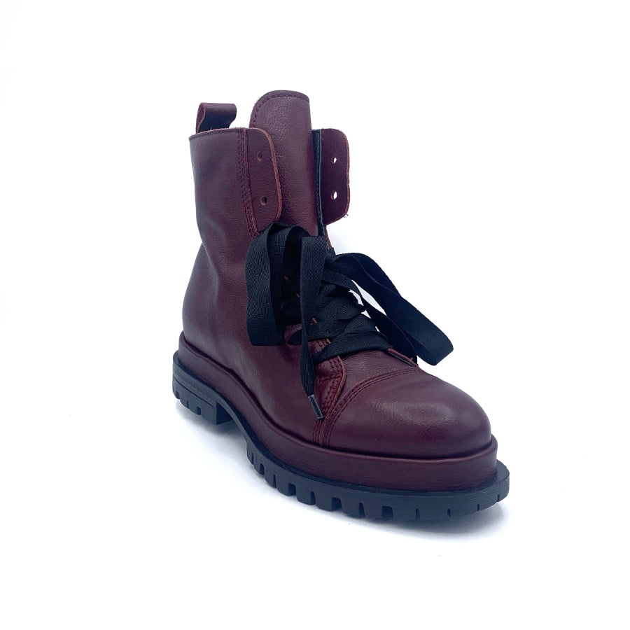 Outer front view of the all black ankle tie camper boot. This boot has a lug/combat boot look with wide black laces and an ankle length shaft. These boots are wine colored.
