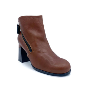 Outer front side view of the all black double zip hi bootie. This bootie is brown/orange colored. It has a zipper on the outer side and the leather color covers up a portion of the mid-height chunky black heel.