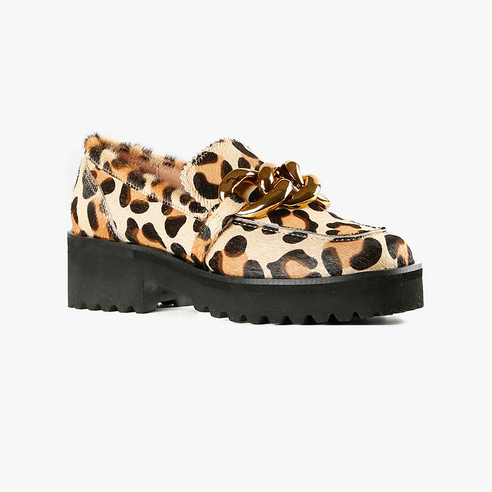 outer side view of the all black footwear chunky lugg lady shoe. This lugg sole shoe has leopard printed calf hair all over the outer and decorative gold chain hardware in the front
