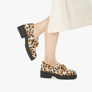 side view of the all black footwear chunky lugg lady shoe. This lugg sole shoe has leopard printed calf hair all over the outer and decorative gold chain hardware in the front