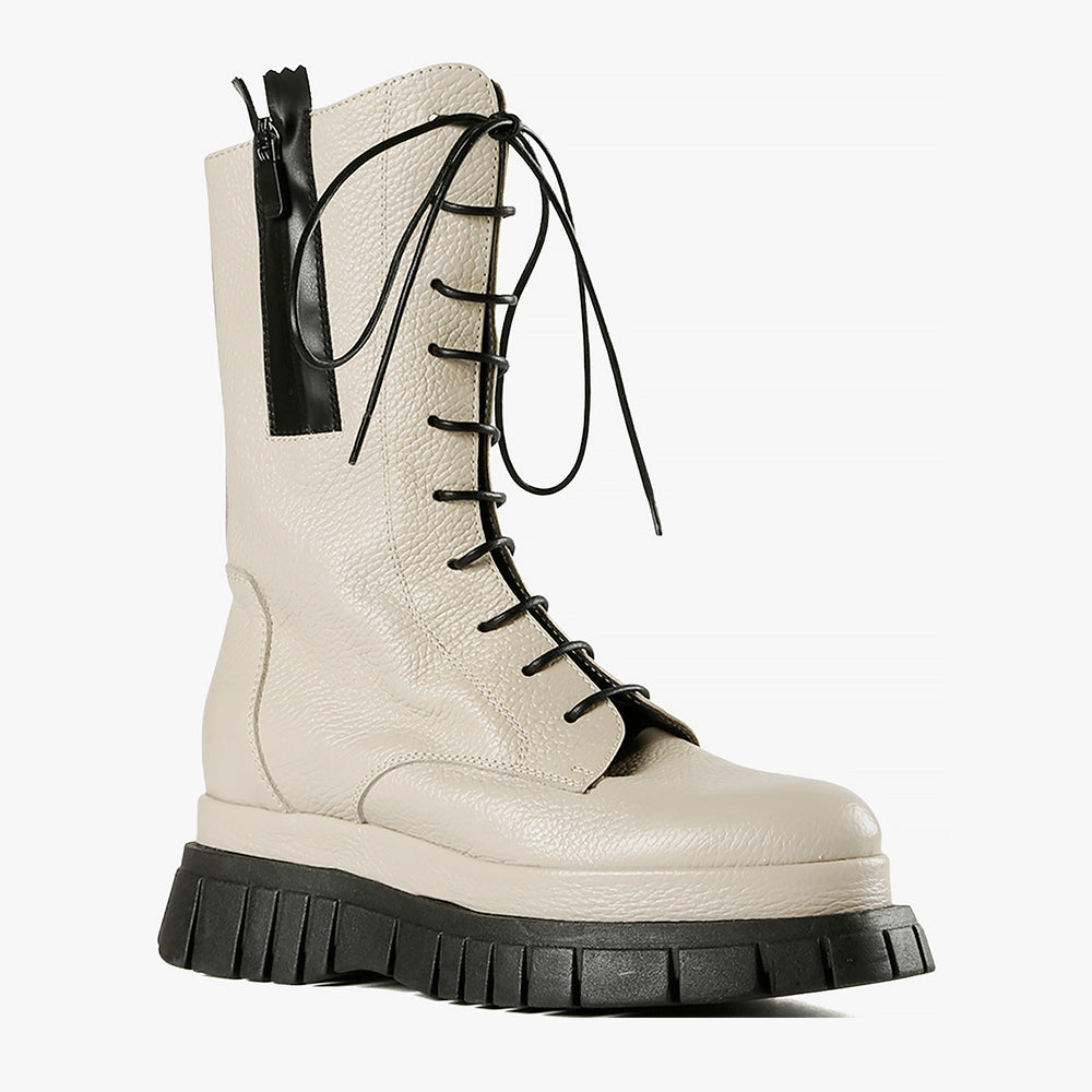 outer side view of the all black lester lace lugg. This boot is ivory colored and has black laces, a black lugg sole, and a black outer zipper.