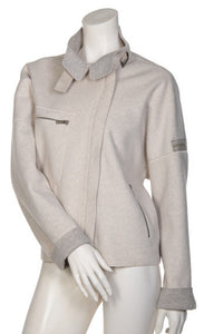 Front view of the beate heymann felty jacket in the color sand. This jacket is off-white with a grey lining that shows on the collar and cuffs. The jacket had drop shoulder cuffed long sleeves, an off center zipper front, a stand collar, and a front zip pocket.