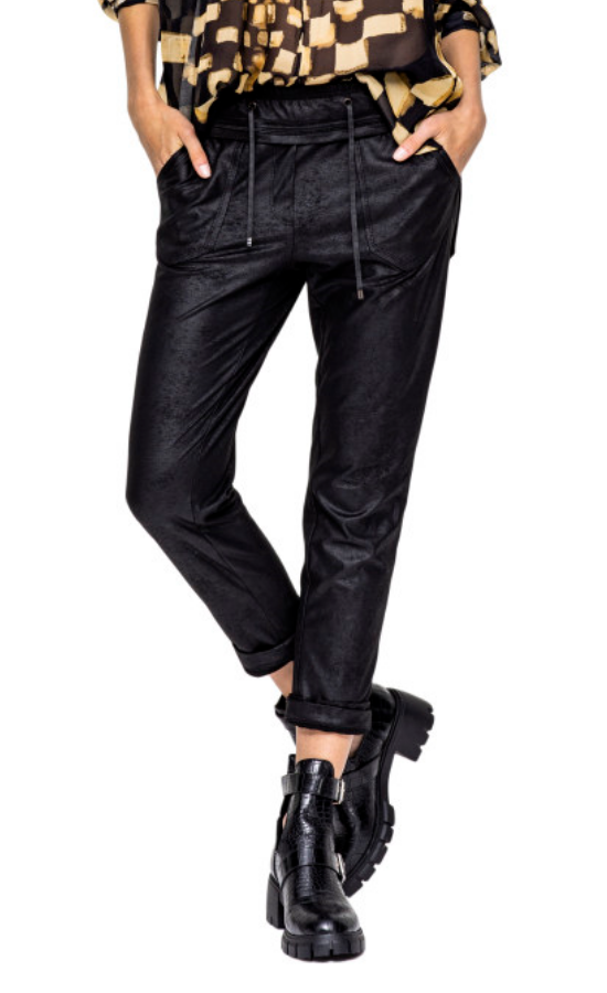 Front bottom half view of a woman wearing the Beate Heymann Signature Cropped Jogger. This jogger is black and looks like leather. It has a drawstring waistband and a cropped rolled up bottom.