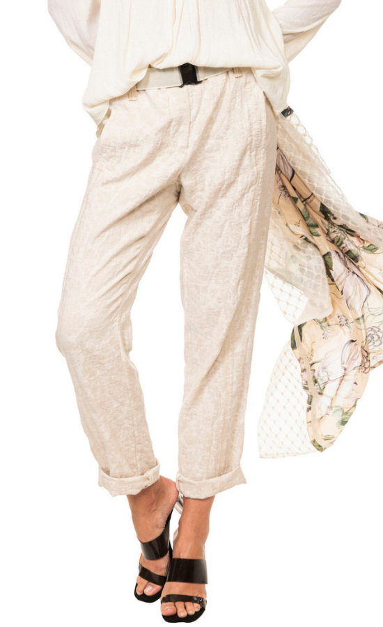 Front bottom half view of a woman wearing a beige top and the beate heymann roll up jacquard trouser. This pant is beige with a floral print. It has a roll up hem, and a beige elastic belt.