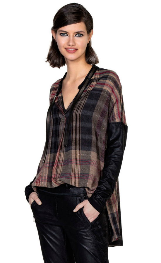 Front top half view of a woman wearing the beate heymann plaid blouse with the beate heymann black joggers. This top is brown with a black and red plaid print. The top has a v-neck and black leather-looking drop shoulder long sleeves. 