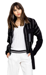 Load image into Gallery viewer, Front, top half view of a woman wearing white pants a white top and the Beate Heymann Stripped Jacket. This jacket is black with white stripes. The sleeves are solid black and the front has two patch, solid black pockets with a single white stripe on them. The jacket has a zip up front and belt near the bottom.
