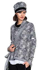 Load image into Gallery viewer, Front top half view of a woman wearing the beate heymann chunky knit pullover. This top has long sleeves, a mock neck with black lining, and a grey, loose knit appearance.
