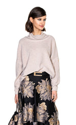 Load image into Gallery viewer, Front top half view of a woman wearing a skirt and the beate heymann cozy sweatshirt in the color nature. This color is cream/beige. The sweatshirt has drop shoulder long sleeves and a cowl neck.
