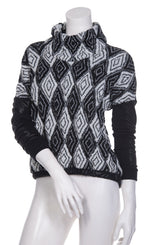 Load image into Gallery viewer, Front top half view of the beate heymann knit rhombus top. This top has a black and white diamond/rhombus print with a mock neck and drop shoulder leather-looking black long sleeves.
