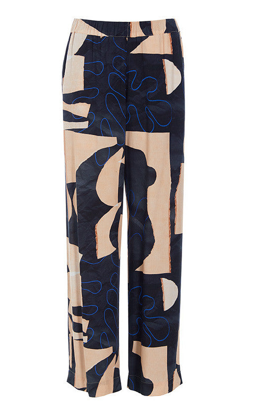 Front view of the bitte kai rand monstera pant. This pant is nude colored with a black and blue abstract pattern on it. The pants are wide legged.