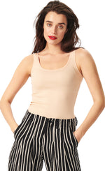 Load image into Gallery viewer, Front top half view of a woman wearing the bitte kai rand atlas rib tank top. This tank top is form fitting and nude colored.
