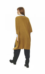 Load image into Gallery viewer, back full body view of a woman wearing black pants, a black and white shirt and the bitte kai rand merino mix cape in the color mustard. This cape has two wide elbow length sleeves and sits below the hips.

