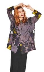 Load image into Gallery viewer, Front full body view of a woman wearing the bitte kai rand grey wilderness shirt. This shirt is grey with a mix of yellow, ice blue, and black flowers. The shirt has a button up front.
