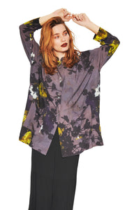 Front full body view of a woman wearing the bitte kai rand grey wilderness shirt. This shirt is grey with a mix of yellow, ice blue, and black flowers. The shirt has a button up front.