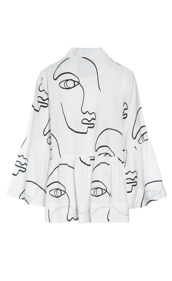 Back view of the bitte kai rand sketch viscose shirt jacket. This shirt is white with black sketch faces on it. It has long sleeves with ruffles and a ruffles on the bottom half of the top.
