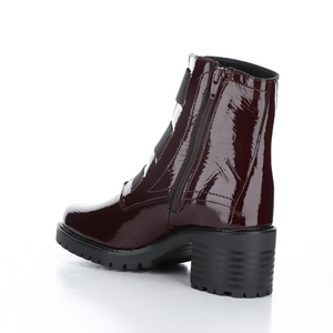 Inner back side view of the Bos & Co patent leather boot in the color bordeaux/bordo. This boot has a chunky mid-heel and 3 elastic bands on the front.
