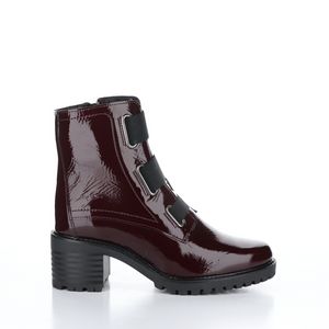 Outer side view of the Bos & Co patent leather boot in the color bordeaux/bordo. This boot has a chunky mid-heel and 3 elastic bands on the front.