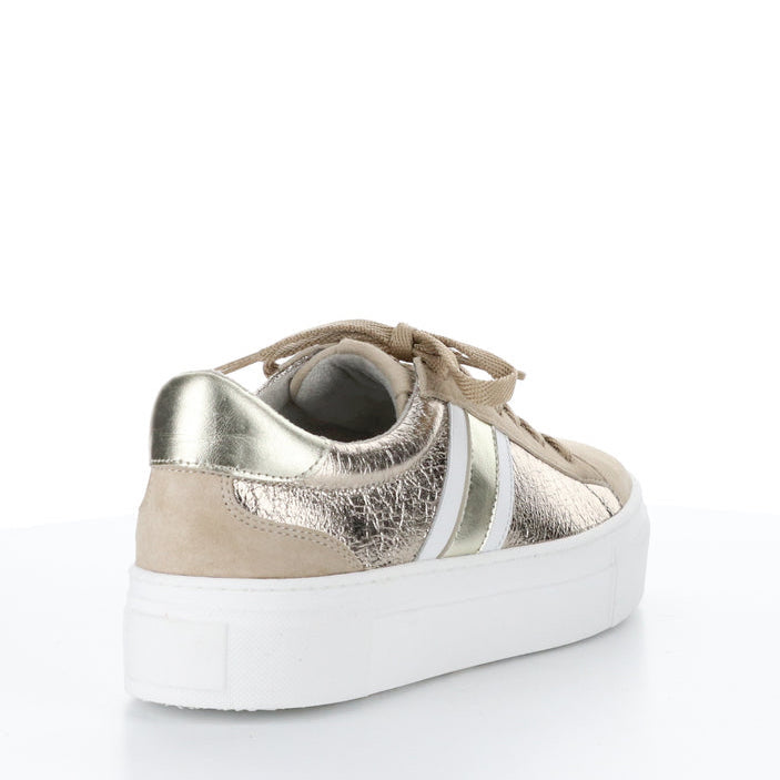 Outer back side of the bos & co monic sneaker. This sneaker is beige with crinkled metallic sides, white and silver side stripes, a lace up front, and a platform sole.