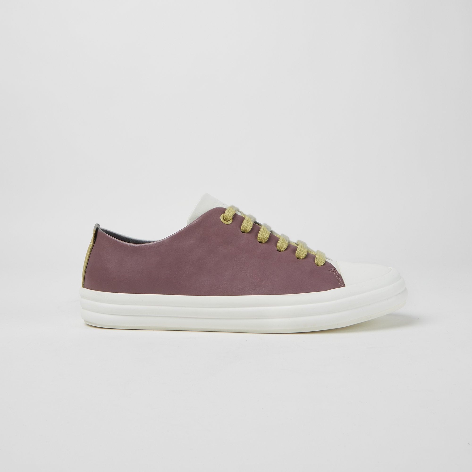 Outer side view of the right foot of the camper twins sneaker. The outer side of the right foot is purple with a white toe and sole. The laces are mustard colored.