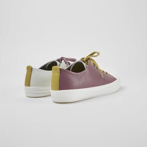 Back side view of a pair of the camper twins sneaker. The left sneaker is white on the inside. The right sneaker is purple on the outer side. The back of both sneakers have mustard pull tabs.