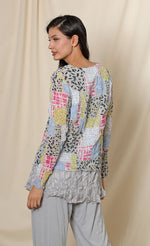 Load image into Gallery viewer, Back top half view of a woman wearing the chalet andrea basic top. This top has long sleeves, crinkled fabric, and a multicolored patchwork print.
