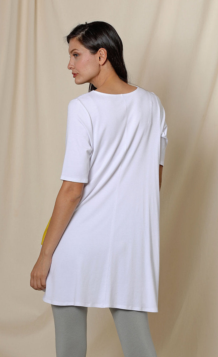 Back top half view of a woman wearing the chalet fallon tunic. This tunic is white and sits below the hips.