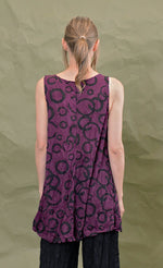 Load image into Gallery viewer, Back top half view of a woman wearing the chalet liz tank in acai. This tank is purple colored with a black circles.
