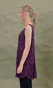 left side top half view of a woman wearing the chalet liz tank in acai. This tank is purple colored with a black circles.