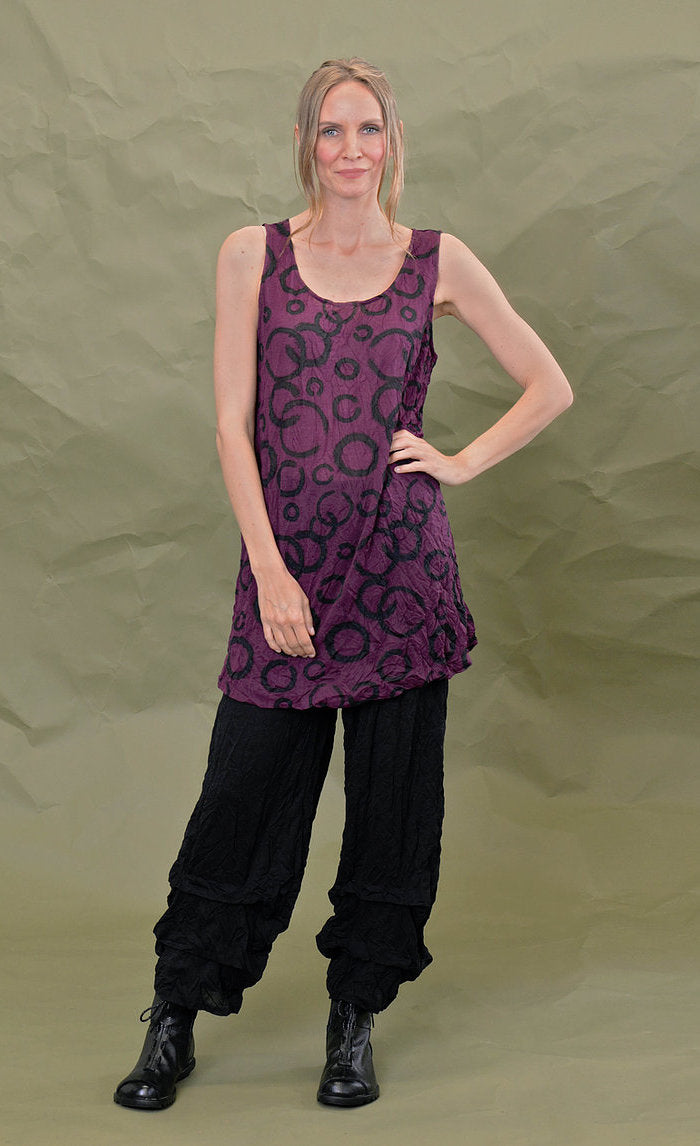 Front full body view of a woman wearing the chalet liz tank in acai. This tank is purple colored with a black circles.