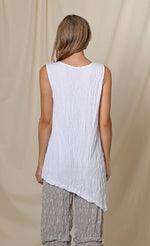 Load image into Gallery viewer, Back top half view of a woman wearing the chalet lucianna tunic. This tunic is sleeveless. The back of it is solid white. The tunic has an asymmetrical hem. 

