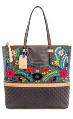 Load image into Gallery viewer, Front view of the consuela silverlake market tote. This tote is grey with a quilted like bottom and light tan trim. The straps are thin. On the front of the tote is blue pink and orange floral embroidery.
