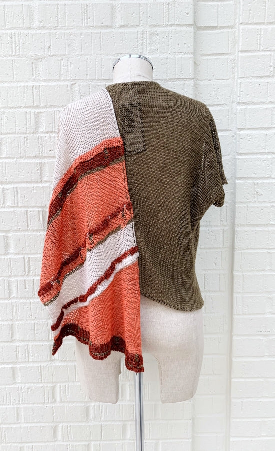 Back view of the crea concept asymmetrical knit top. This top is brown on the right side with a short sleeve and salmon and brown striped on the left side with a sleeveless, draped look. 