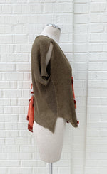Load image into Gallery viewer, Right side view of the crea concept asymmetrical knit top. The right side of this top is brown with a short sleeve.
