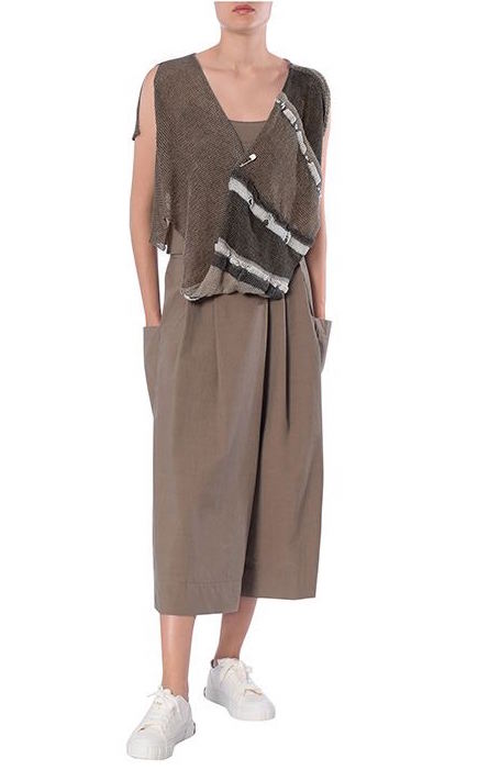 Front view of the crea concept asymmetrical knit top on a woman with brown pants. This version of the top is brown on the right side with a short sleeve and brown and dark brown striped on the left side with a sleeveless, draped look. Both sides come together in the middle of the front with a safety pin.