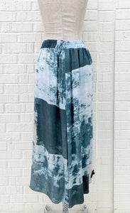 Back view of the crea concept abstract watercolor pant. This pant is wide legged and has a teal watercolor-like print on it. 