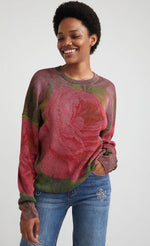 Load image into Gallery viewer, front top half view of a woman wearing the desigual knit flowers sweater. This sweater is ribbed with large pink roses printed all over it. It has long sleeves and a loose fit.
