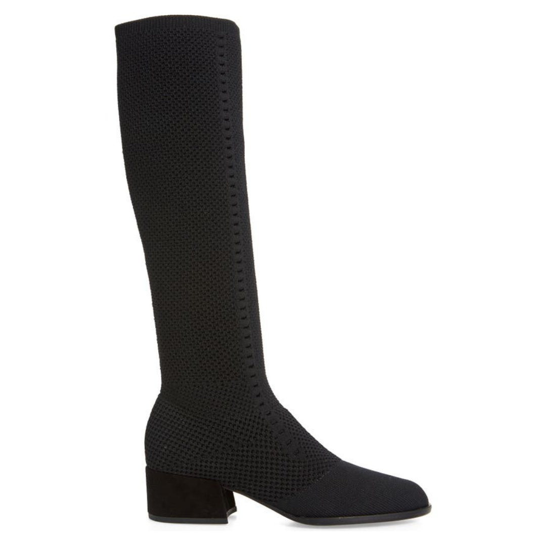 Outer side view of the eileen fisher alas knit boot. This black boot comes up below the knee. It has a knitted fabric upper and a low block heel