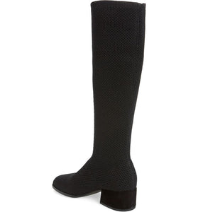 Inner back side view of the eileen fisher alas knit boot. This black boot comes up below the knee. It has a knitted fabric upper and a low block heel